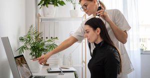 Salon professional performing hair consultation while reviewing results on digital salon software.